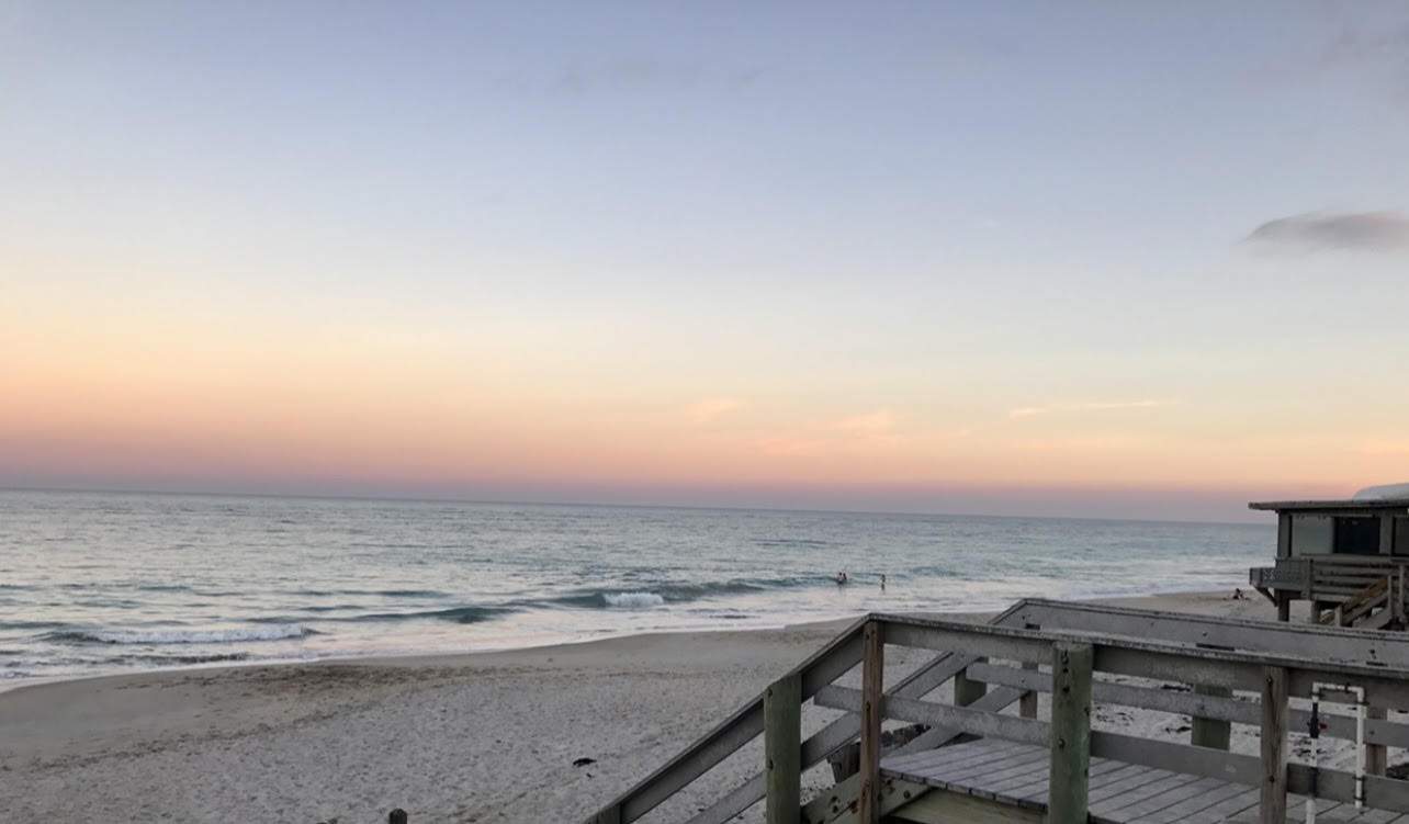 a morning view of the ocean, with stairs leading down to the beach